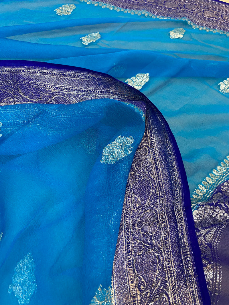 Elevate your style with this classic blue pure Khaddi Chiffon handloom Banarasi saree from Shades of Benares, radiating timeless elegance.