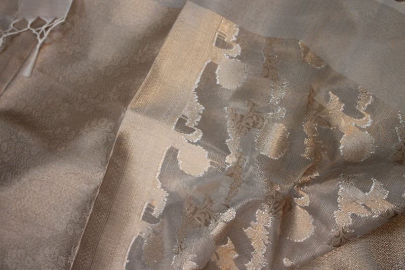Shades of Benares presents a stunning off-white pure tissue silk Banarasi saree with artisanal gold jaal design.