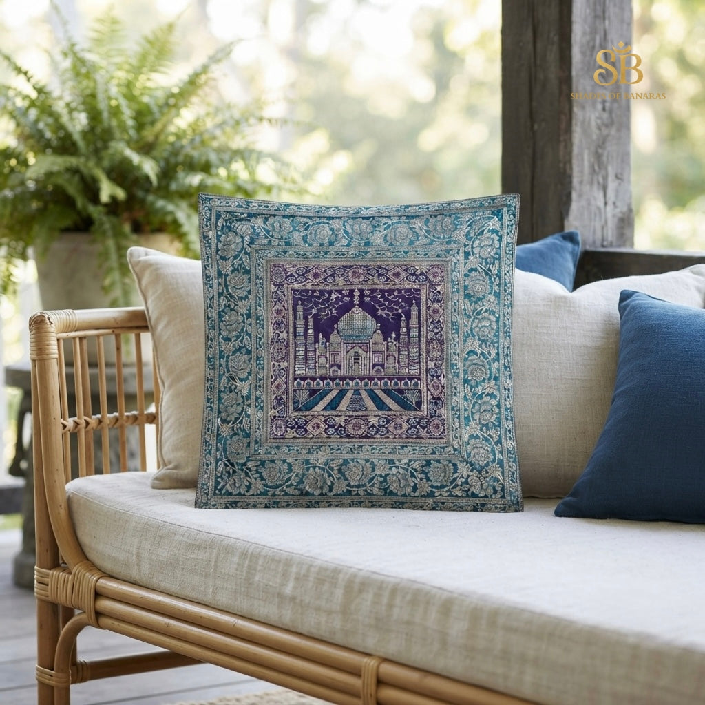 Teal blue brocade Banarasi cushion cover with Taj Mahal motif on a rattan daybed