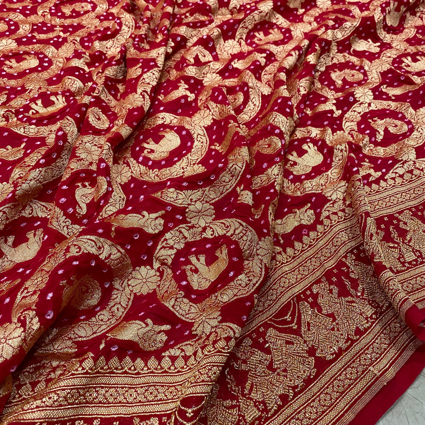 Crimson Heritage: Red Khaddi Georgette Bandhani Saree with Shikargaah Weave The quintessential hue of love, reimagined in the lightest of silks. by Shades Of Banaras - banarasi - banarasi saree shop - banarasi saree manufacturers - banarasi saree wholesale - banaraasi sarees