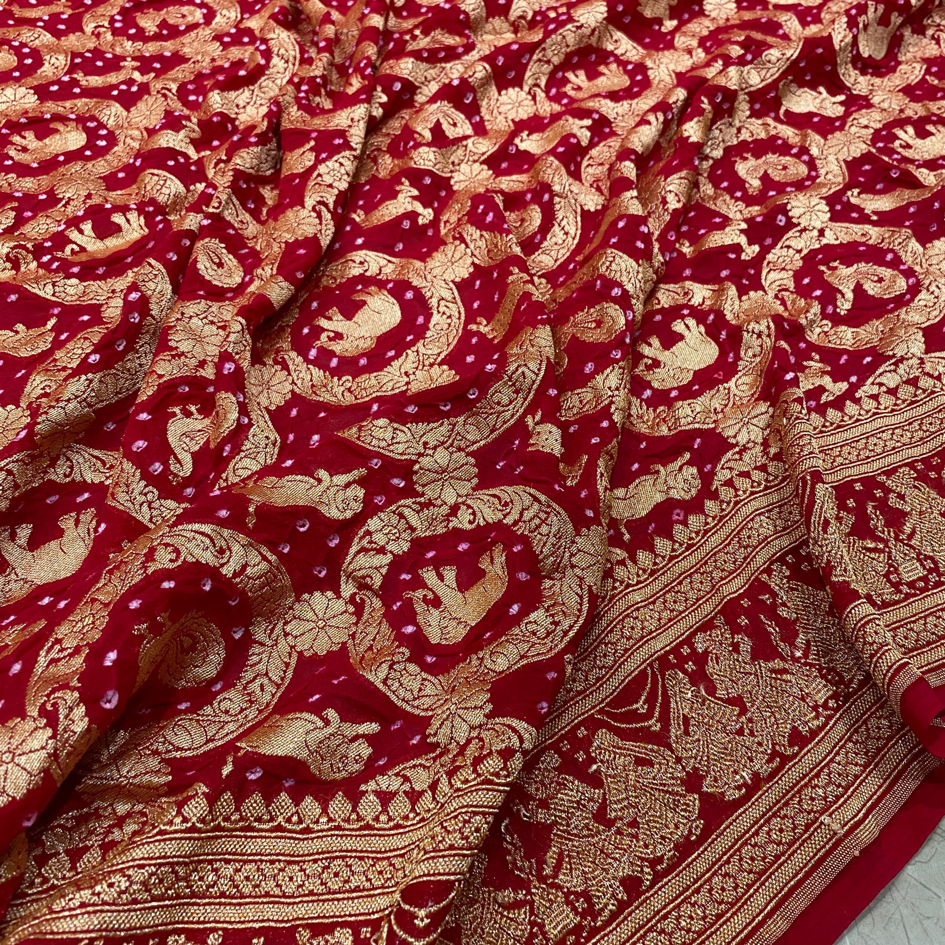 Crimson Heritage: Red Khaddi Georgette Bandhani Saree with Shikargaah Weave The quintessential hue of love, reimagined in the lightest of silks. by Shades Of Banaras - banarasi - banarasi saree shop - banarasi saree manufacturers - banarasi saree wholesale - banaraasi sarees