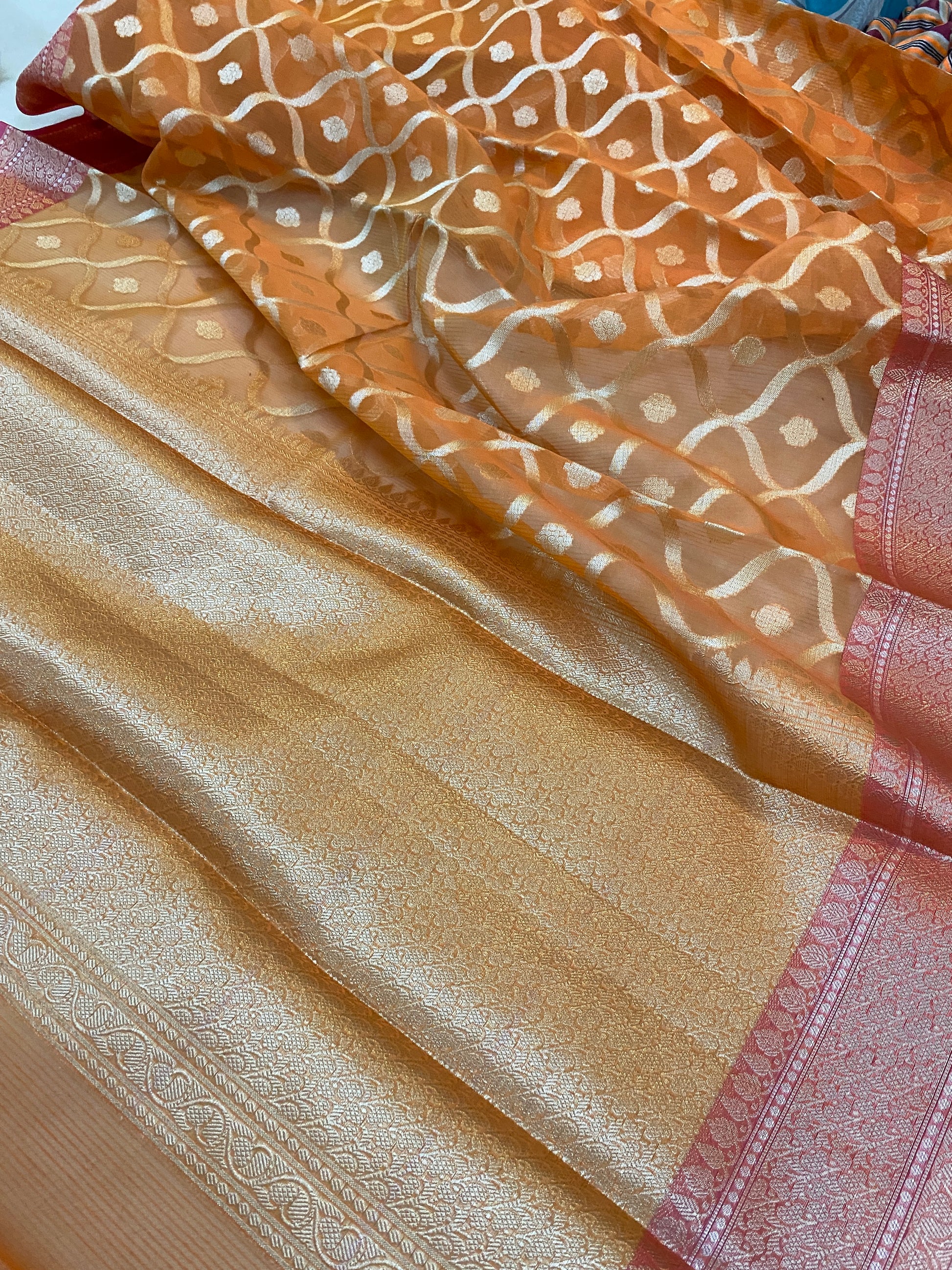 Orange Jaal Pure Kora Silk Handloom Banarasi Saree by shades of benaras: A stunning orange saree with intricate jaal design, made from pure kora silk using handloom techniques.