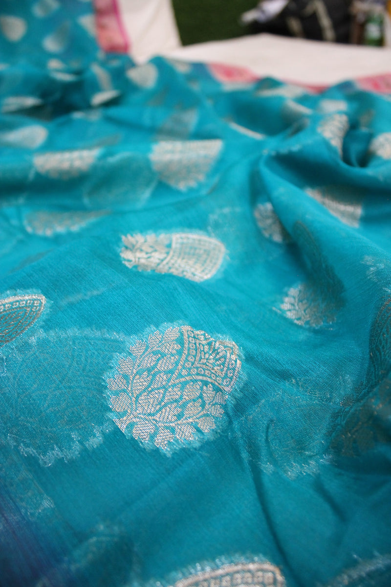 Seablue Kora Organza Handloom Banarasi Saree with Pink Border by shades of benares - a stunning saree with a pink border.