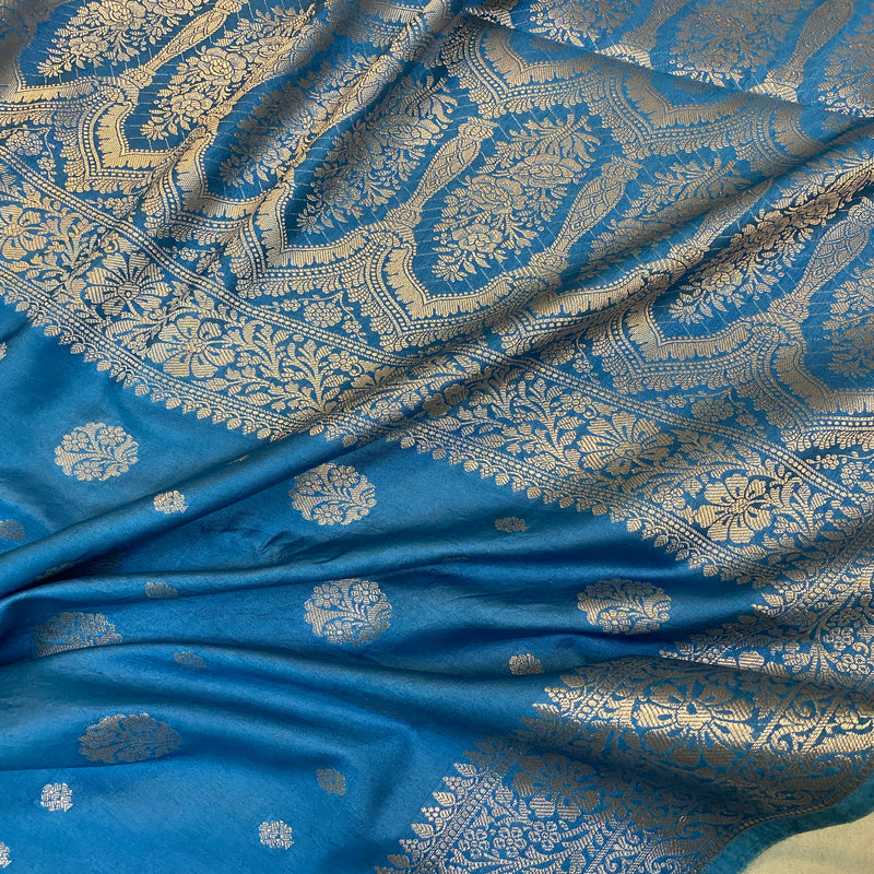 Elevate your look with our matte blue handloom crepe Banarasi silk saree. Perfect for formal events and festive celebrations, exuding understated elegance and artisanal craftsmanship.