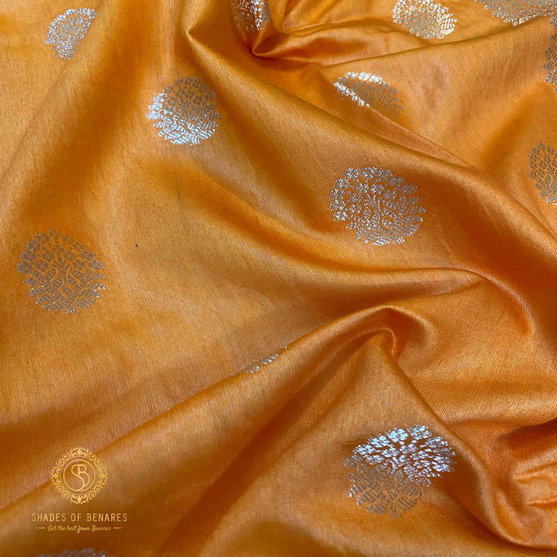 Vibrant orange handloom crepe Banarasi silk sari, showcasing traditional artistry and luxurious silk fabric. Exudes boldness and elegance, ideal for weddings, festive celebrations, or cultural events.
