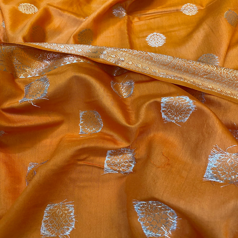 Orange handloom crepe Banarasi silk sari, crafted with traditional artistry and luxurious silk fabric, radiates boldness and elegance.
