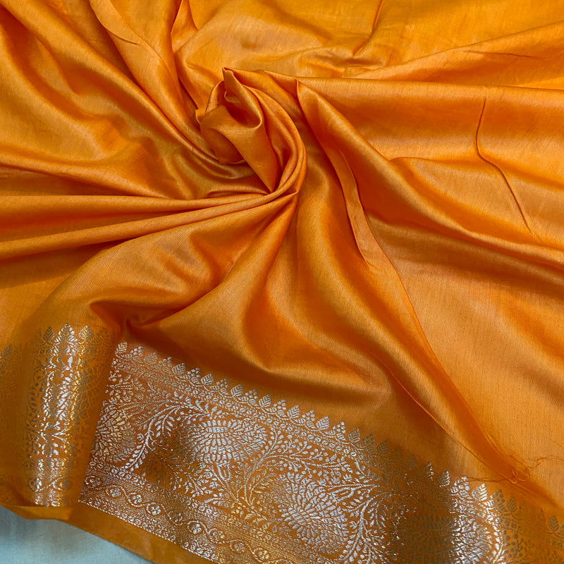 Traditional craftsmanship meets modern style in this vibrant orange handloom crepe Banarasi silk sari. Perfect for weddings and cultural events.