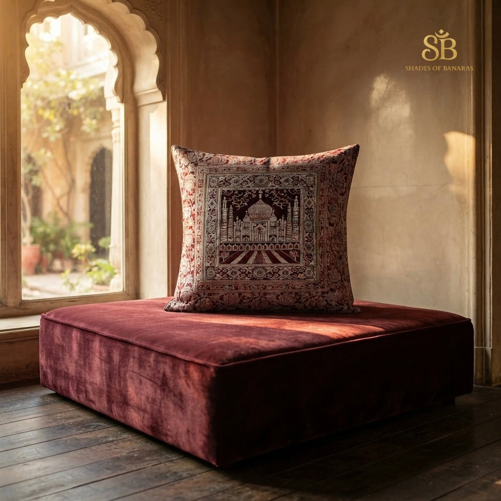 Maroon brocade Banarasi cushion cover with Taj Mahal motif on a velvet floor seat