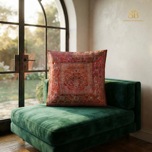 Red brocade Banarasi cushion cover with floral rosette medallion on a green velvet seat