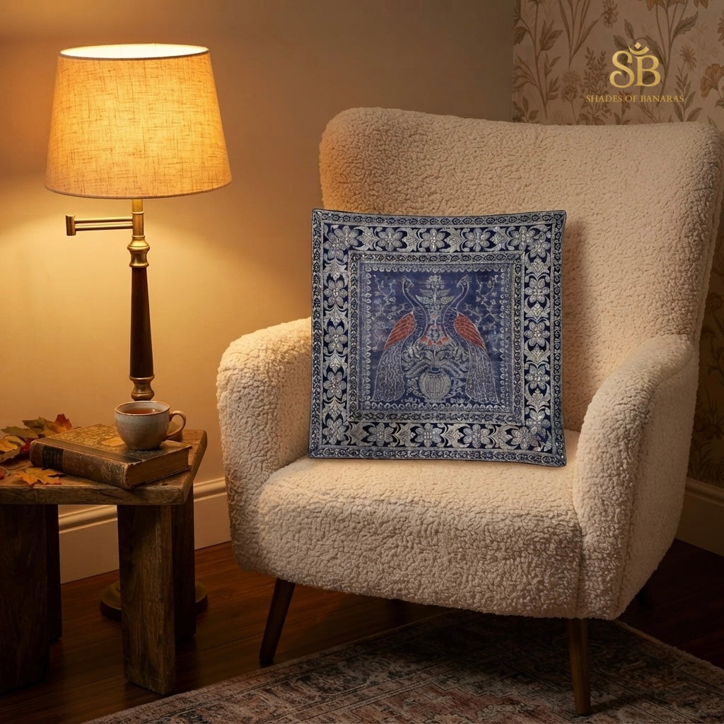 Blue brocade Banarasi cushion cover with bird and urn motif on a cream boucle chair