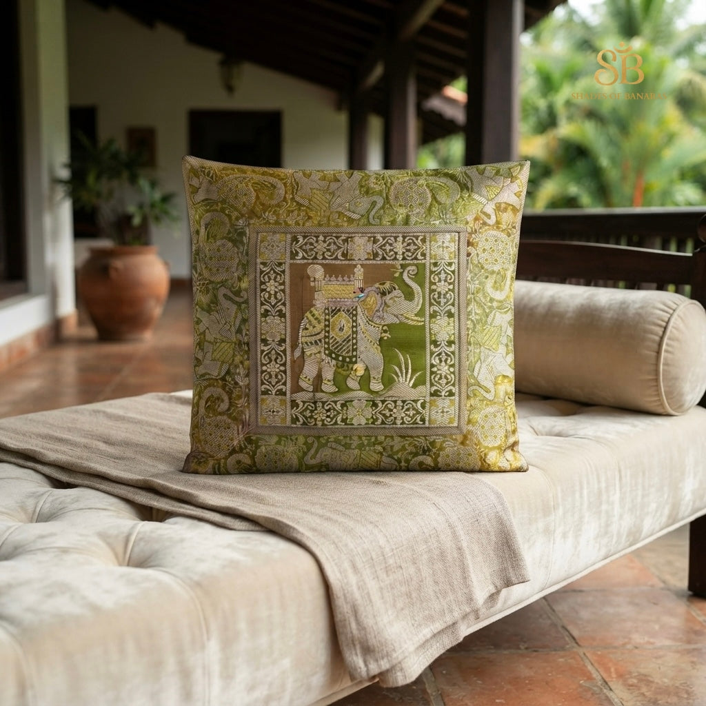 Green brocade Banarasi cushion cover with elephant motif on a veranda daybed