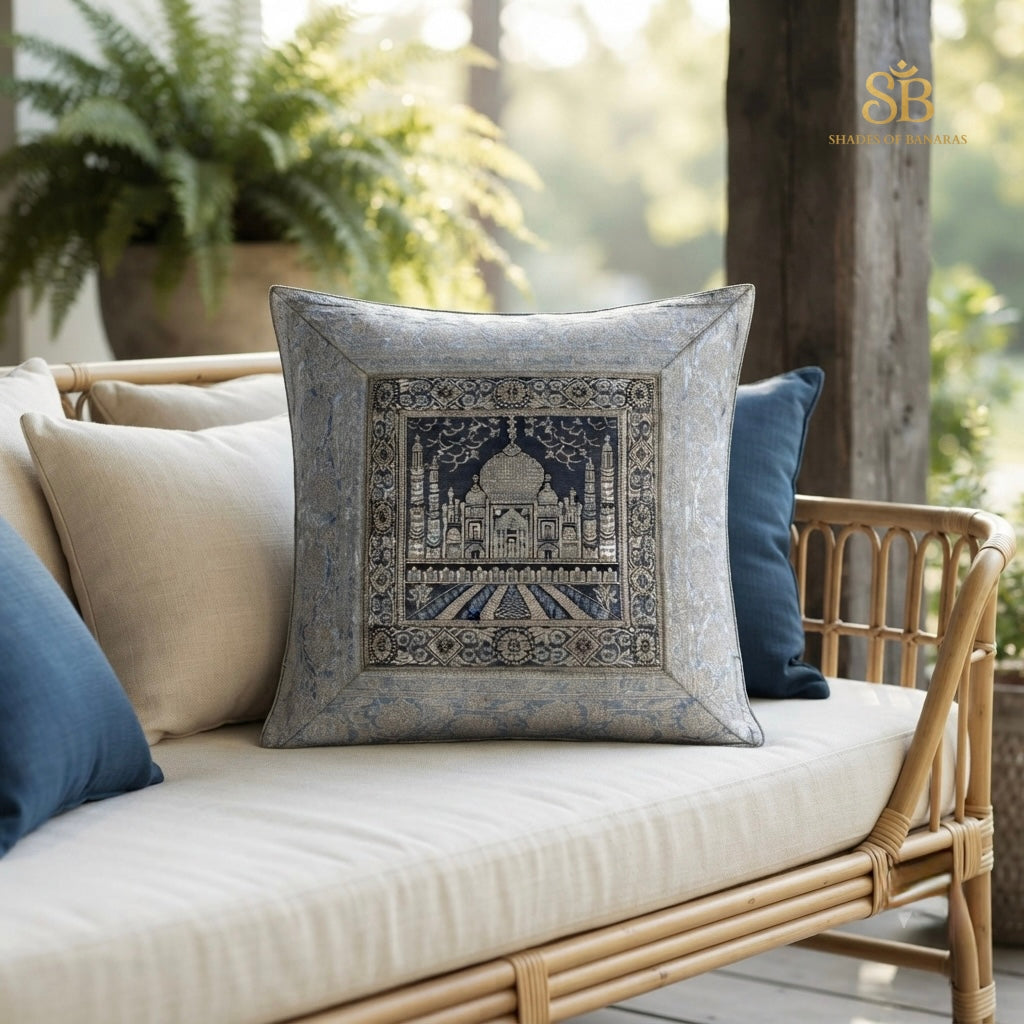 Grey brocade Banarasi cushion cover with Taj Mahal motif and mitred border on a rattan sofa