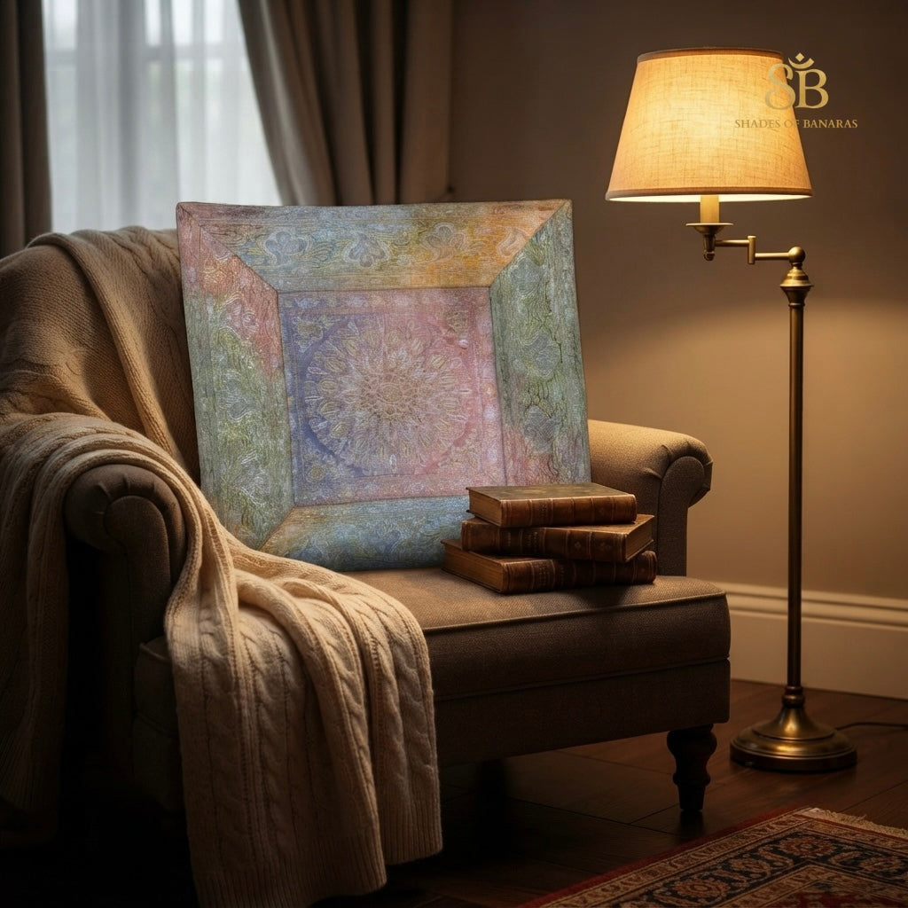 Multicolor pastel brocade Banarasi cushion cover with mandala on a chair beside a lamp