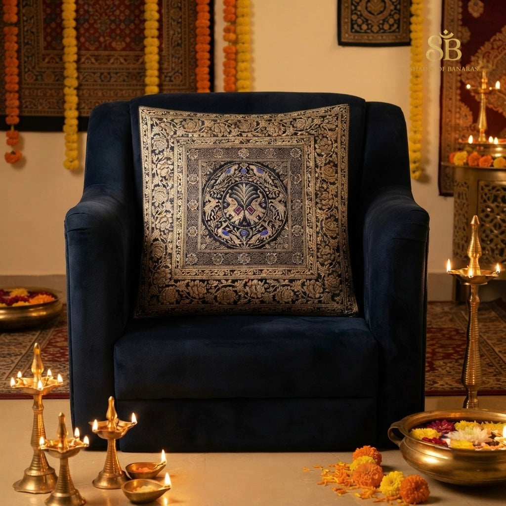Black brocade Banarasi cushion cover with gold zari peacock medallion on a navy velvet chair
