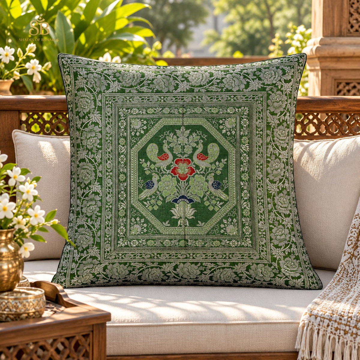 Green brocade Banarasi cushion cover with peacock octagon motif on a garden sofa