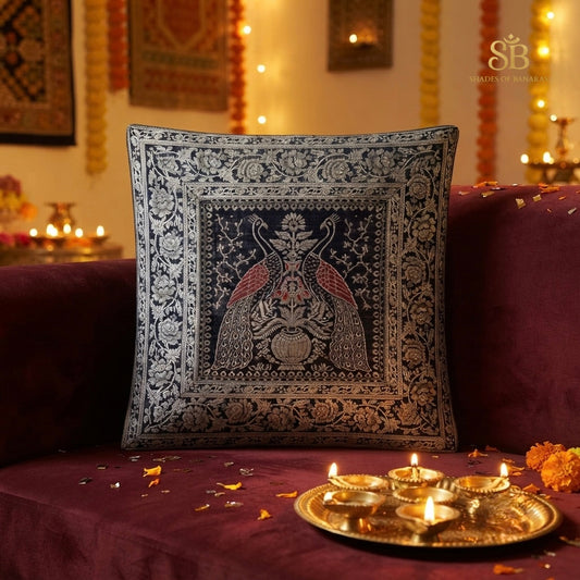 Navy blue pure brocade Banarasi handloom cushion cover with peacock pair motif on a wine velvet sofa