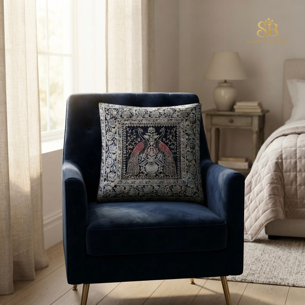Dark blue pure brocade Banarasi handloom cushion cover with peacock pair motif on a navy velvet armchair